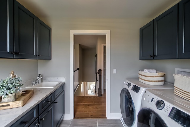 laundry area featuring a sink, cabinet space, washing machine and clothes dryer, and baseboards