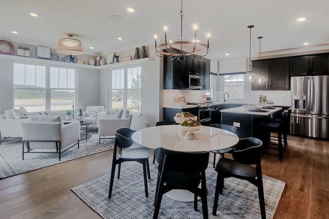 dining room with a notable chandelier, wood finished floors, and plenty of natural light