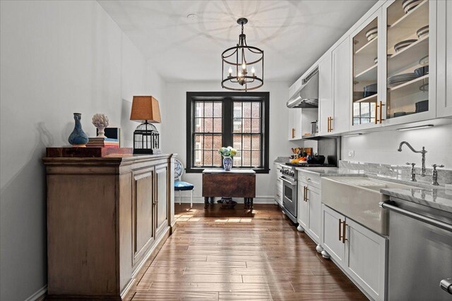 1316 Maple Ave Unit B2, Evanston, IL 60201 - kitchen featuring a chandelier, stainless steel appliances, under cabinet range hood, white cabinetry, and wood finished floors