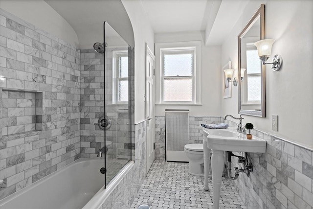 1316 Maple Ave Unit B2, Evanston, IL 60201 - bathroom with tiled shower / bath combo, radiator, toilet, tile walls, and wainscoting