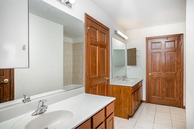 bathroom with a sink, tile patterned flooring, a bathtub, and two vanities