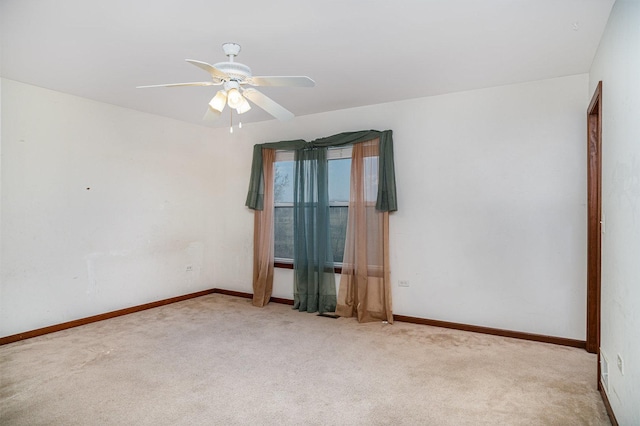 unfurnished room with carpet floors, a ceiling fan, and baseboards