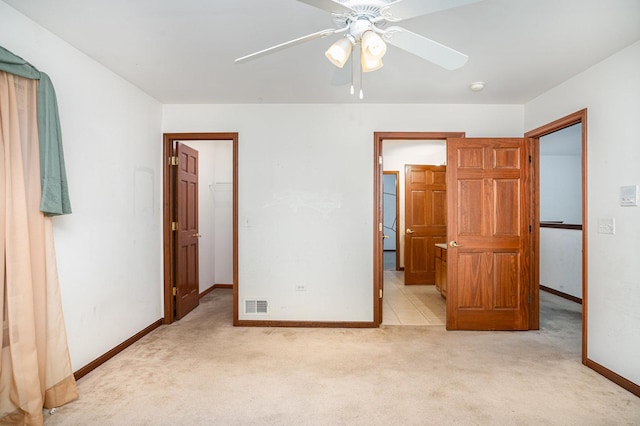unfurnished bedroom featuring light carpet, baseboards, a spacious closet, visible vents, and a closet