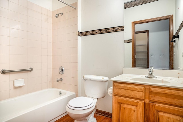 full bathroom with vanity, wood finished floors, toilet, baseboards, and shower / washtub combination