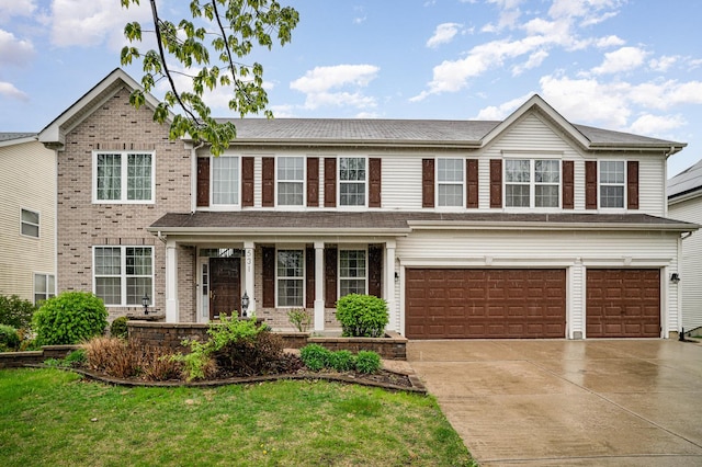view of front of house with a porch, driveway, a garage, brick siding, and a front lawn