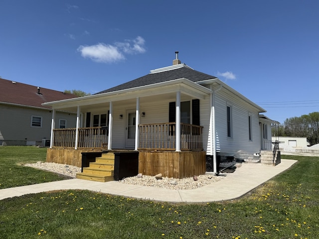 view of front facade featuring a front lawn, central AC, and covered porch
