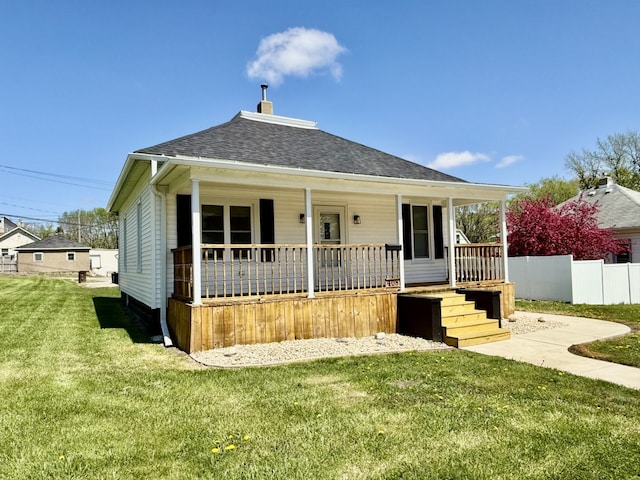 view of front of property featuring roof with shingles, a porch, and a front lawn