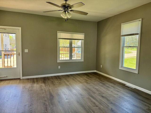 unfurnished room with dark wood-type flooring, plenty of natural light, and ceiling fan