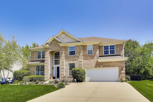 traditional-style house featuring driveway, a front yard, a garage, and brick siding