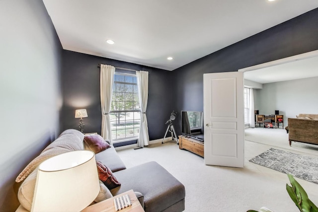 carpeted living area featuring recessed lighting and baseboards