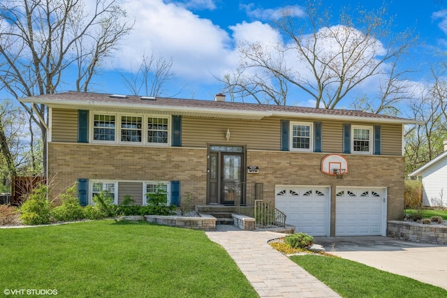 split foyer home featuring a chimney, a front yard, a garage, brick siding, and concrete driveway