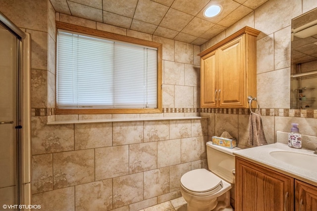 bathroom with vanity, toilet, tile walls, and a stall shower