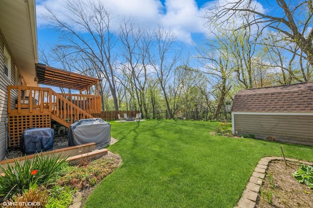 view of yard featuring a storage shed, stairway, a deck, a fenced backyard, and an outdoor structure