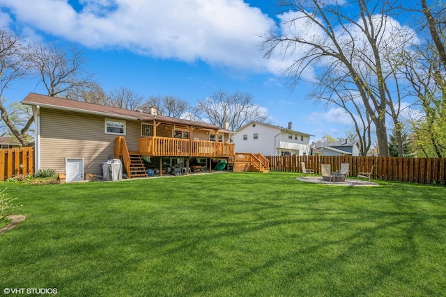 back of house with stairway, a deck, a yard, and a fenced backyard