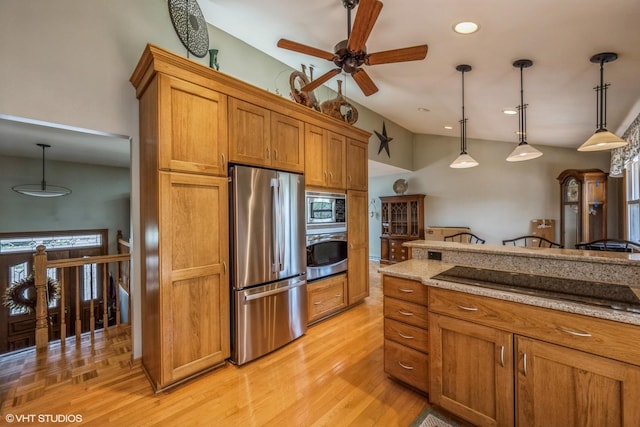 kitchen with hanging light fixtures, appliances with stainless steel finishes, ceiling fan, and brown cabinets