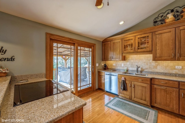 kitchen featuring a sink, light wood-style floors, dishwasher, brown cabinetry, and lofted ceiling