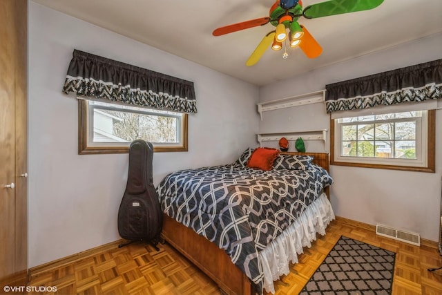 bedroom featuring visible vents, a ceiling fan, and baseboards