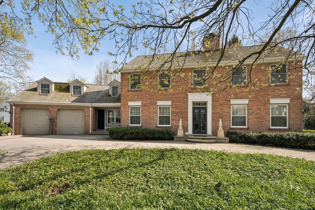 54 Indian Hill Rd, Winnetka, IL 60093 - colonial inspired home featuring a chimney, driveway, brick siding, a garage, and a front lawn