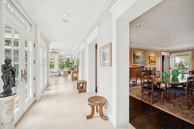 hall featuring crown molding, plenty of natural light, french doors, and wood-type flooring