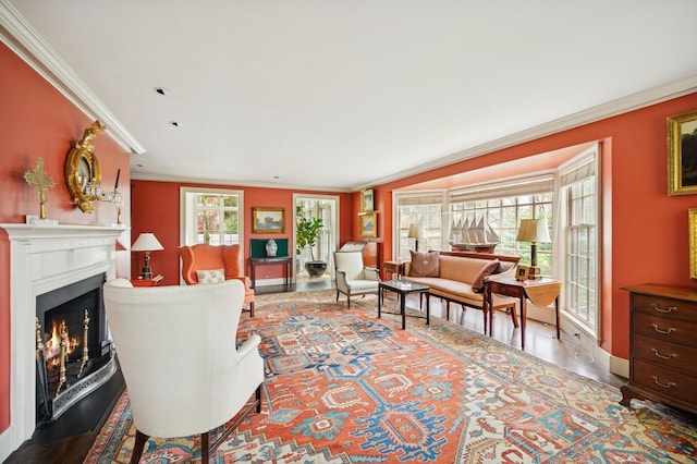 living room with crown molding, a wealth of natural light, a warm lit fireplace, and wood finished floors