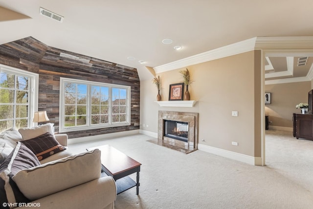 carpeted living area featuring a premium fireplace, crown molding, visible vents, and baseboards