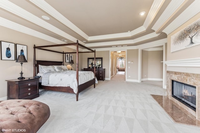 bedroom featuring light carpet, a fireplace, baseboards, a raised ceiling, and crown molding