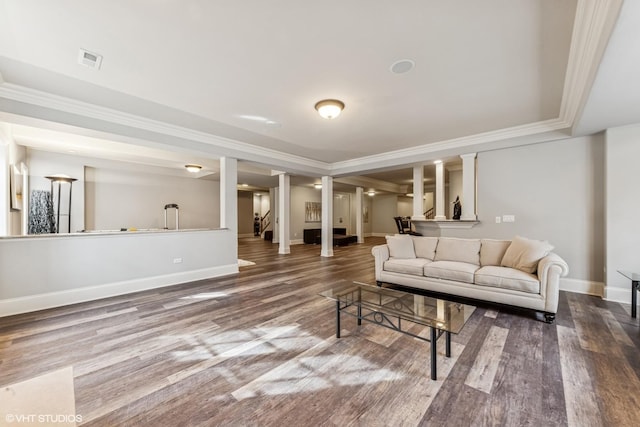 living area featuring baseboards, visible vents, wood finished floors, and crown molding