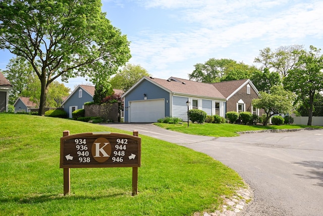 ranch-style house with a front yard, a garage, and driveway