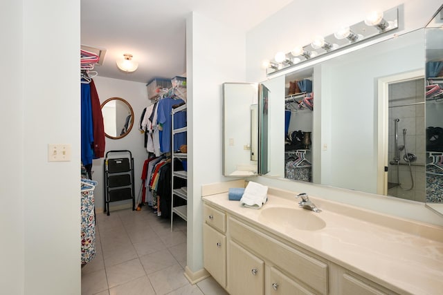 full bath with tile patterned flooring, a walk in closet, vanity, and a shower