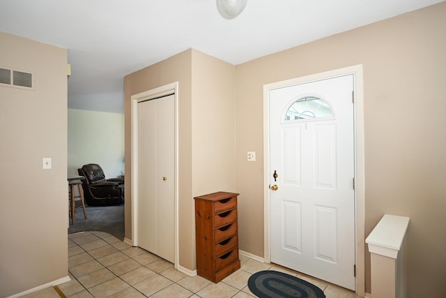 foyer entrance featuring light tile patterned floors and baseboards
