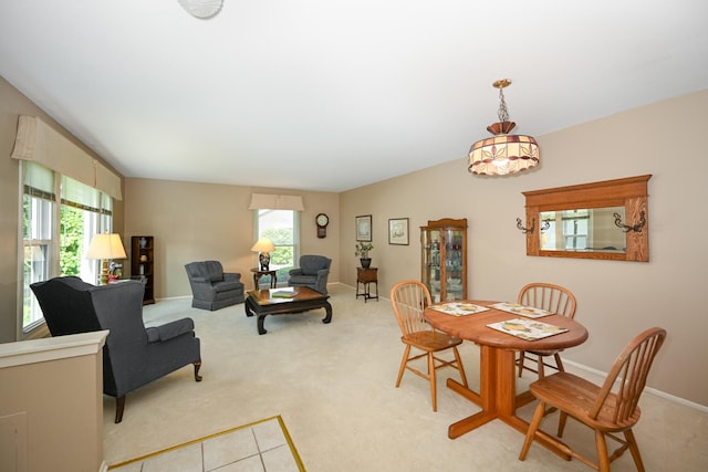 dining space with plenty of natural light, light carpet, and baseboards