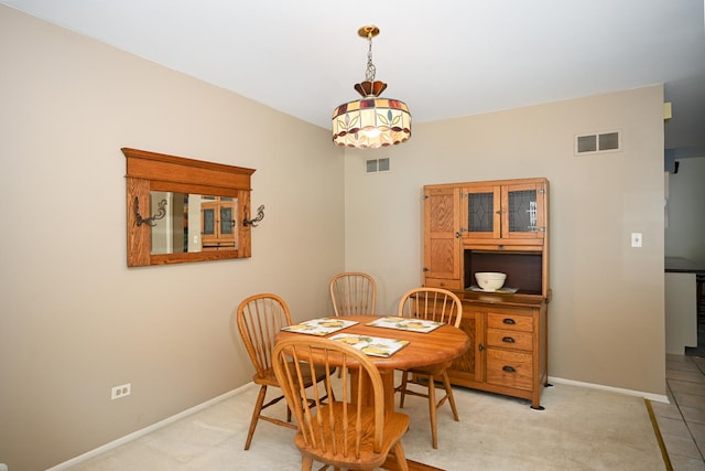 dining room with baseboards and light colored carpet