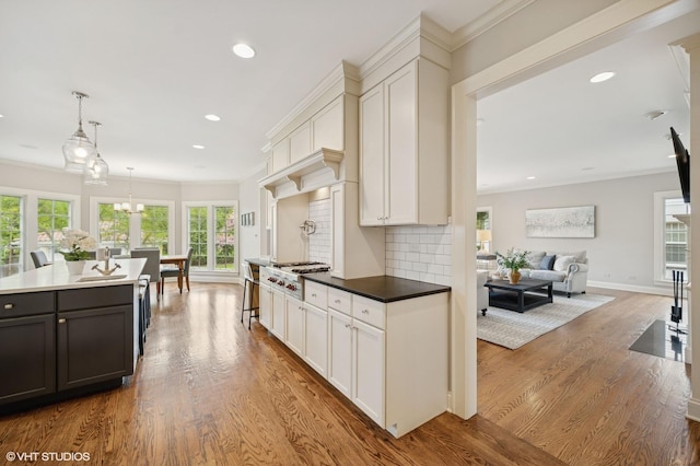 495 Willow Rd, Winnetka, IL 60093 - kitchen with stainless steel gas stovetop, wood finished floors, white cabinetry, ornamental molding, and baseboards