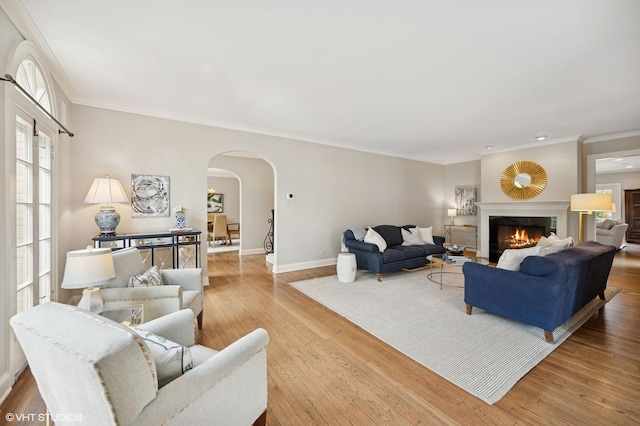 495 Willow Rd, Winnetka, IL 60093 - living room featuring arched walkways, ornamental molding, baseboards, wood finished floors, and a glass covered fireplace
