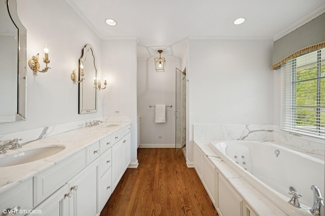 495 Willow Rd, Winnetka, IL 60093 - bathroom featuring a tub with jets, a stall shower, double vanity, wood finished floors, and crown molding