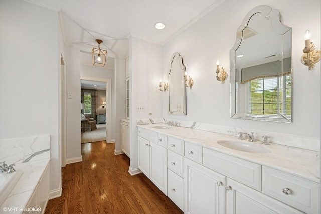495 Willow Rd, Winnetka, IL 60093 - full bathroom with double vanity, wood finished floors, a tub with marble appearance, crown molding, and recessed lighting