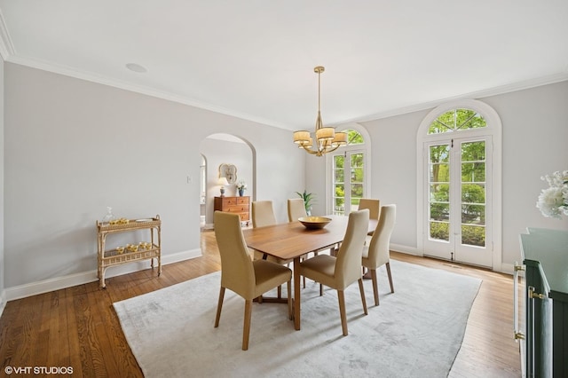 495 Willow Rd, Winnetka, IL 60093 - dining room with arched walkways, a chandelier, ornamental molding, light wood-type flooring, and baseboards