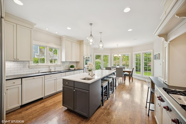 495 Willow Rd, Winnetka, IL 60093 - kitchen with a sink, a breakfast bar, appliances with stainless steel finishes, plenty of natural light, and crown molding