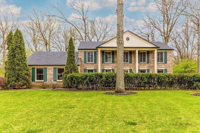 view of front facade featuring brick siding and a front yard
