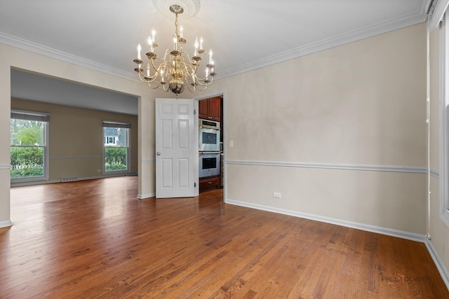 unfurnished dining area with crown molding, baseboards, an inviting chandelier, and wood finished floors