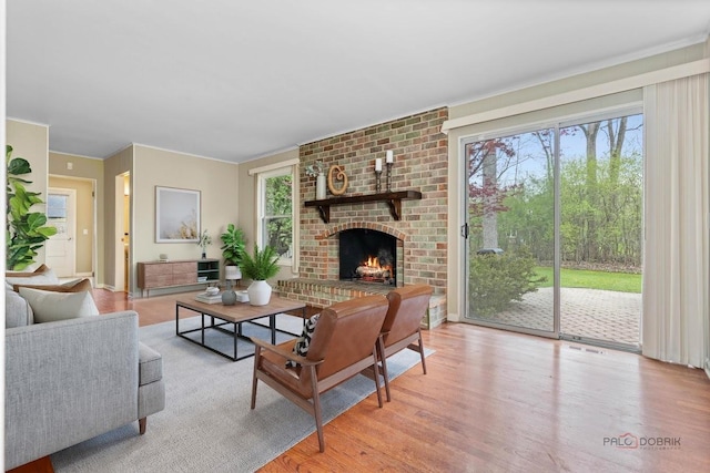 living room featuring light wood-style flooring and a brick fireplace
