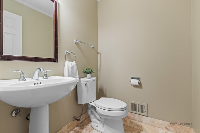 bathroom featuring visible vents, crown molding, tile patterned flooring, and toilet
