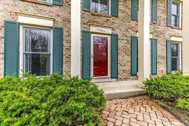 view of exterior entry with brick siding