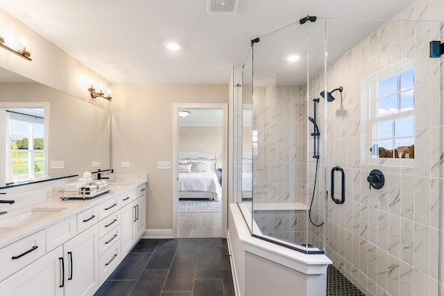 ensuite bathroom featuring a sink, a shower stall, connected bathroom, tile patterned floors, and double vanity