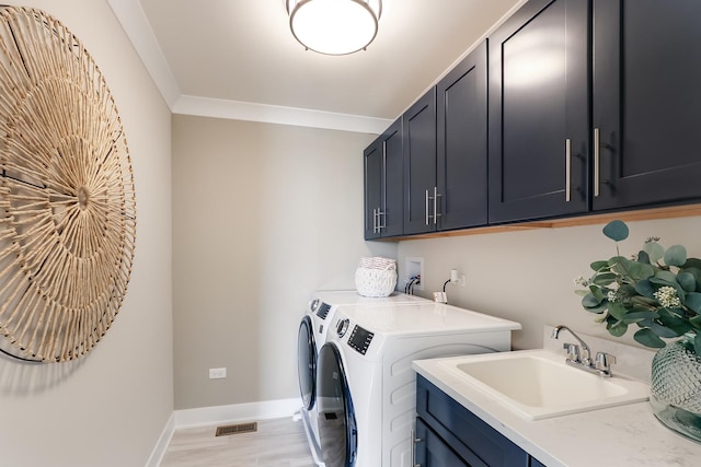 clothes washing area featuring a sink, washing machine and clothes dryer, cabinet space, visible vents, and baseboards