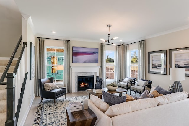 living area featuring stairway, a premium fireplace, wood finished floors, and crown molding