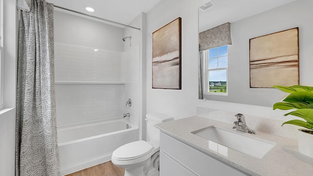 full bath featuring vanity, shower / bath combo with shower curtain, toilet, visible vents, and wood finished floors