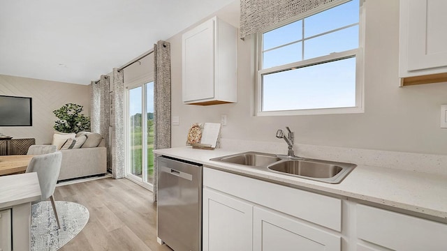 kitchen with white cabinetry, light wood-style floors, dishwasher, and a sink