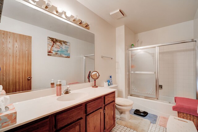 full bath featuring toilet, tile patterned floors, shower / bath combination with glass door, and vanity