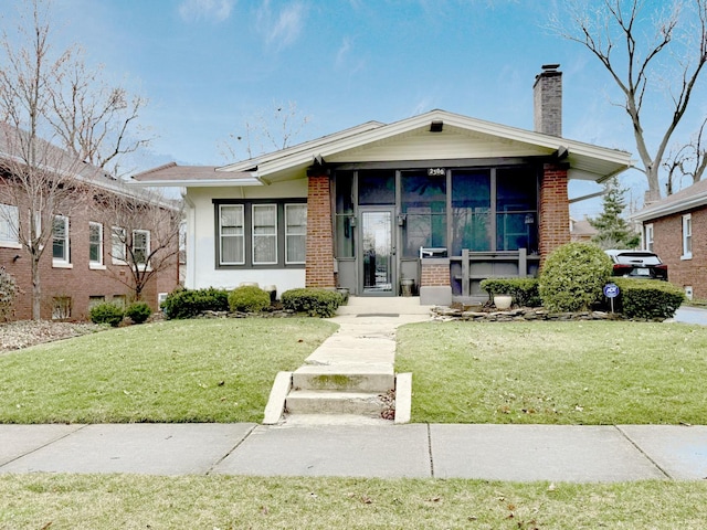 view of front of house with a chimney, stucco siding, and a front yard
